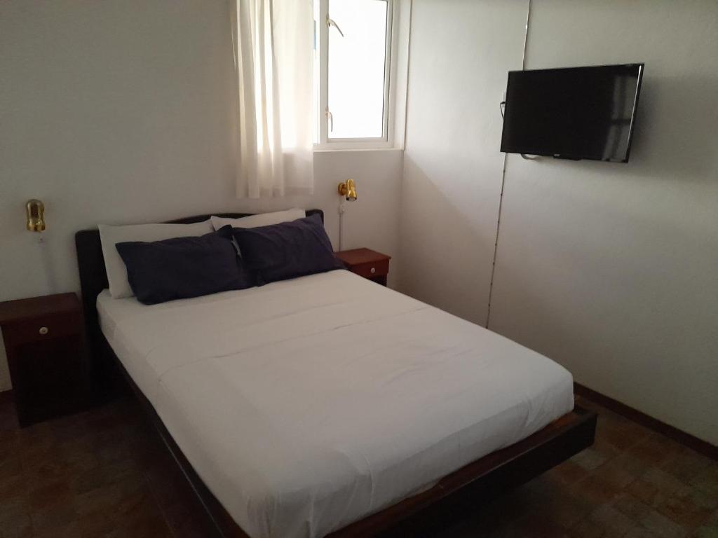 Double bedroom with white linen at Auberge Miko in Grand Baie