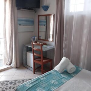 Guest room with desk and balcony doors at CHILLpill Guest House in Mahébourg