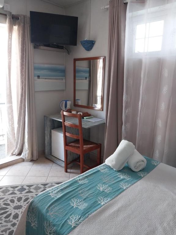 Guest room with desk and balcony doors at CHILLpill Guest House in Mahébourg