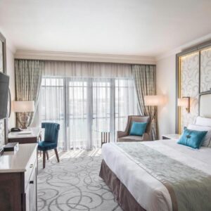 Guest room with a large bed and balcony doors at Labourdonnais Waterfront Hotel in Port Louis