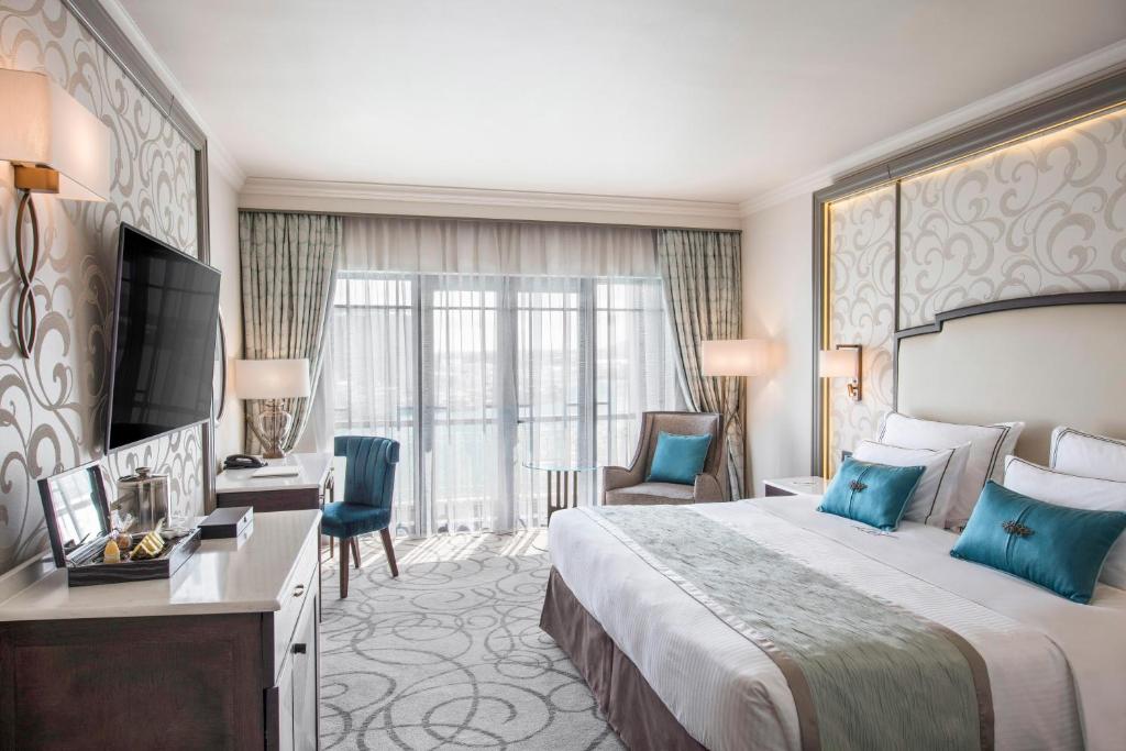 Guest room with a large bed and balcony doors at Labourdonnais Waterfront Hotel in Port Louis